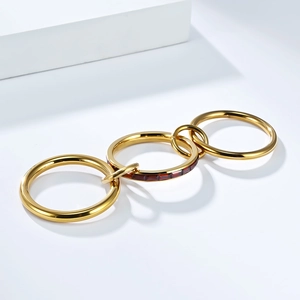 Detalle de tres anillos entrelazados de oro con circonitas rojas de talla baguette
