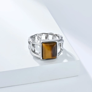 Détail macro d'une bague cubaine en acier pour homme avec une pierre œil de tigre carrée