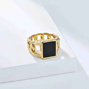 Vue macro d'une bague à chaîne cubaine dorée avec un insert carré en émail noir poli