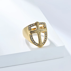 Macro shot of gold-plated shield ring with cross relief and clear zircon inlay