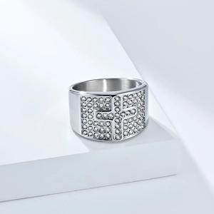 Macro detail of iced-out silver cross ring showing pavé set cubic zirconia stones