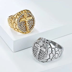 Macro detail of iced-out hip hop Jesus cross ring with textured scale band on white blocks