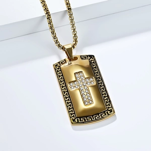 Close-up of gold stainless steel cross pendant with Greek key motif and cubic zirconia