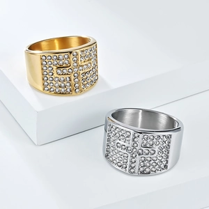 Close-up of gold and silver plated stainless steel rings with iced out cross design