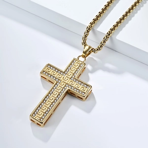 Macro-detail van gouden titanium stalen kruisketting met Grieks patroon en kristallen