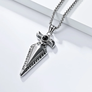 Macro view of Viking spearhead pendant with black stone and Nordic runes on white stone
