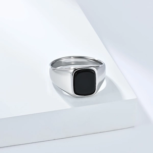 Macro detail van zilveren titanium ring met zwarte edelsteen op geometrisch platform