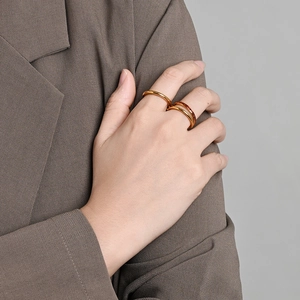 Detalle del conjunto de anillos dorados de doble capa en la mano con acabado pulido