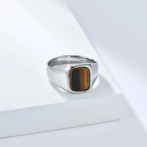 Gepolijste titanium stalen ring met rechthoekige tijgeroog edelsteen op wit blok