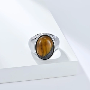 Gros plan de la bague en argent avec pierre oeil de tigre sur socle blanc minimaliste