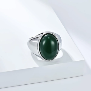Détail macro d'une bague polie pour hommes avec pierre précieuse verte ovale sur socle