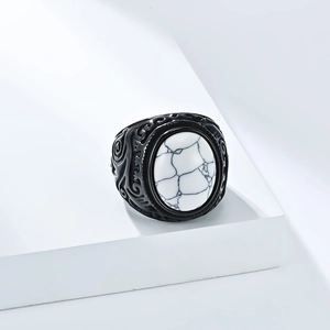 Dettaglio macro di anello vintage da uomo in acciaio con turchese bianco e intagli