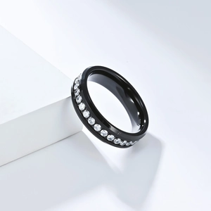 Primer plano de un anillo de tungsteno negro pulido con una hilera completa de circonitas