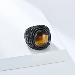 Vista dettagliata di un anello retrò da uomo in acciaio nero con occhio di tigre e incisioni
