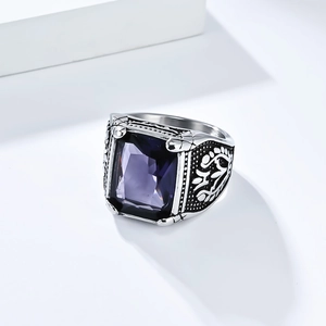Makro-Detail des Vintage-Edelstahlrings mit rechteckigem violettem Edelstein und Blumengravur