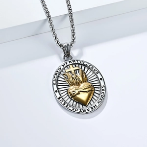 Detailed macro view of silver and gold Sacred Heart of Jesus religious pendant necklace