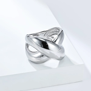 Polished silver-tone layered cross ring with a fluid metal design on a white platform