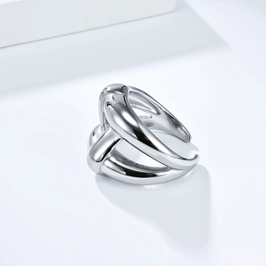 Détail d'une bague géométrique argentée multicouche avec surface polie et structure ouverte