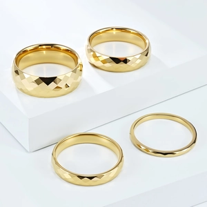 Detail view of four gold tungsten rings with diamond-cut rhombus facets on white steps
