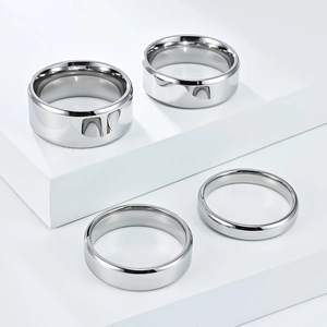Polished stainless steel rings set with dual beveled edges on a white geometric stand