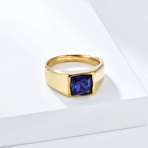 Makroaufnahme: Goldener Edelstahlring mit quadratischem tiefblauem Edelsteinbesatz