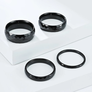 Detailed view of black faceted tungsten steel rings with geometric diamond cut surface