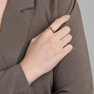 Close-up of rose gold tungsten ring with diamond-cut geometric facets on a model hand