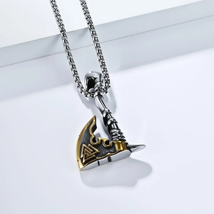 Detail of Viking axe pendant with golden Valknut symbol and textured metal finish