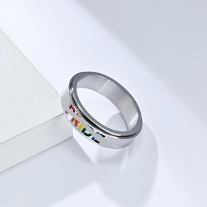 Detailed close-up of rotating stainless steel ring featuring rainbow PRIDE engraving