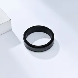 Macro detail of black stainless steel spinner ring with rainbow PRIDE lettering