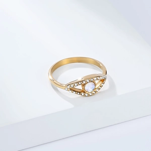Golden evil eye ring with moonstone center and white zircon stones on a white background