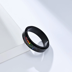 Close-up of black stainless steel pride ring with colorful rainbow PRIDE lettering