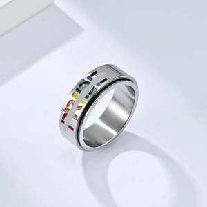 Macro shot of spinning PRIDE ring with rainbow enamel drip design on stainless steel