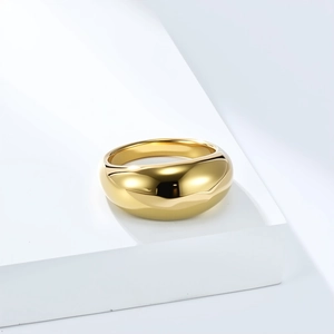Macro shot of chunky gold minimalist ring with a high-polished mirror finish on a pedestal