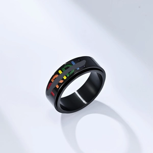 Detail of black stainless steel spinning ring featuring colorful Pride lettering