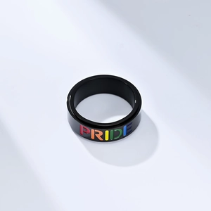 Black stainless steel spinner ring with colorful Pride lettering on white background