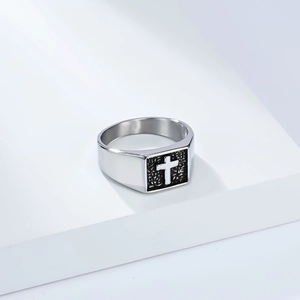 Gros plan d'une bague chevalière carrée en argent avec un motif de croix noire