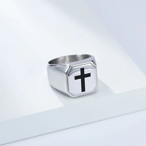 Detailed view of the square signet ring with a black cross on a silver metal surface