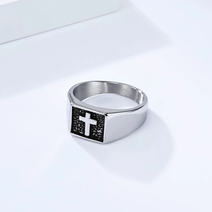 Gros plan détaillé d'une bague chevalière carrée avec croix 3D sur fond noir texturé
