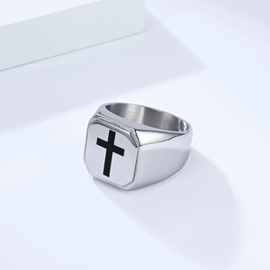 Detail of silver titanium steel signet ring with black cross on a square surface