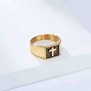 Détail macro d'une bague chevalière dorée en titane pour homme sur un socle blanc