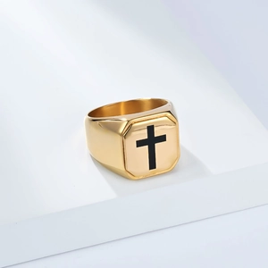 Macro shot of gold wide signet ring with black cross symbol on a white pedestal