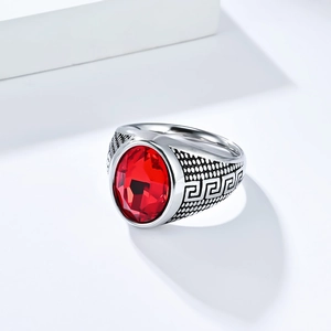 Makroaufnahme eines Vintage-Herrenrings aus Stahl mit rotem Edelstein und Mäander-Muster