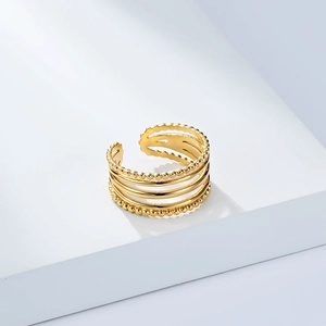 Detail of multi-layer 18K gold plated ring with beaded edges on a white pedestal