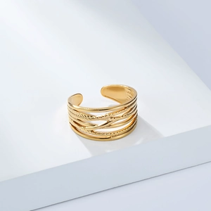 Detailed close-up of 18K gold-plated multi-layer twisted open ring on geometric stand