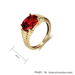 Gros plan sur une pierre ovale rouge de 10mm sertie sur une bague dorée en acier strié