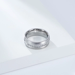 Vue macro de la bague large en argent avec rangée de zircons et texture en métal brossé