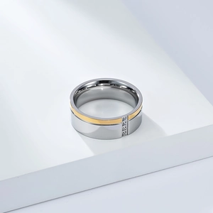 Detalle de anillo bicolor de acero inoxidable con franja dorada y cuatro circonitas