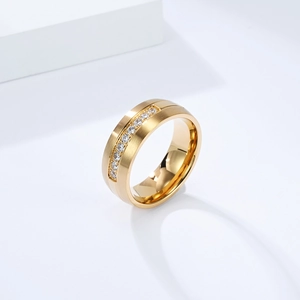 Gros plan d'une bague en acier titane doré avec finition brossée mate et zircons