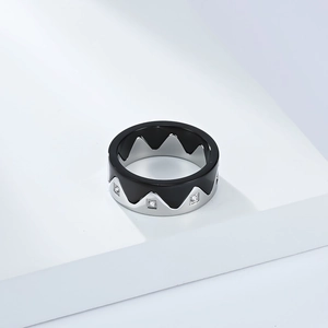 Macro shot of interlocking crown rings with silver and black enamel and small diamonds